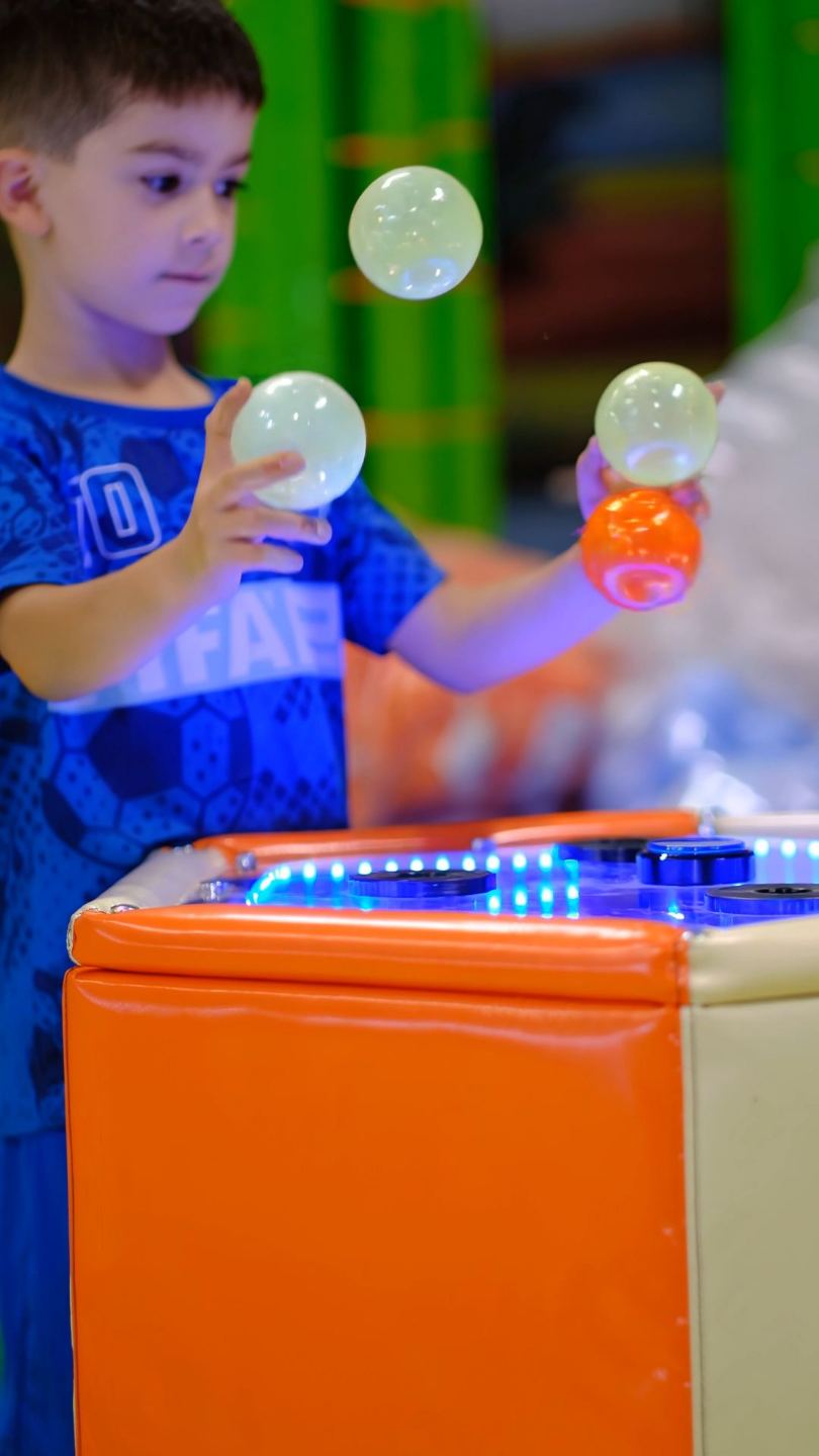 Enfant qui jongle avec des balles lumineuses pendant une animation au parc 123 Soleil Kid's